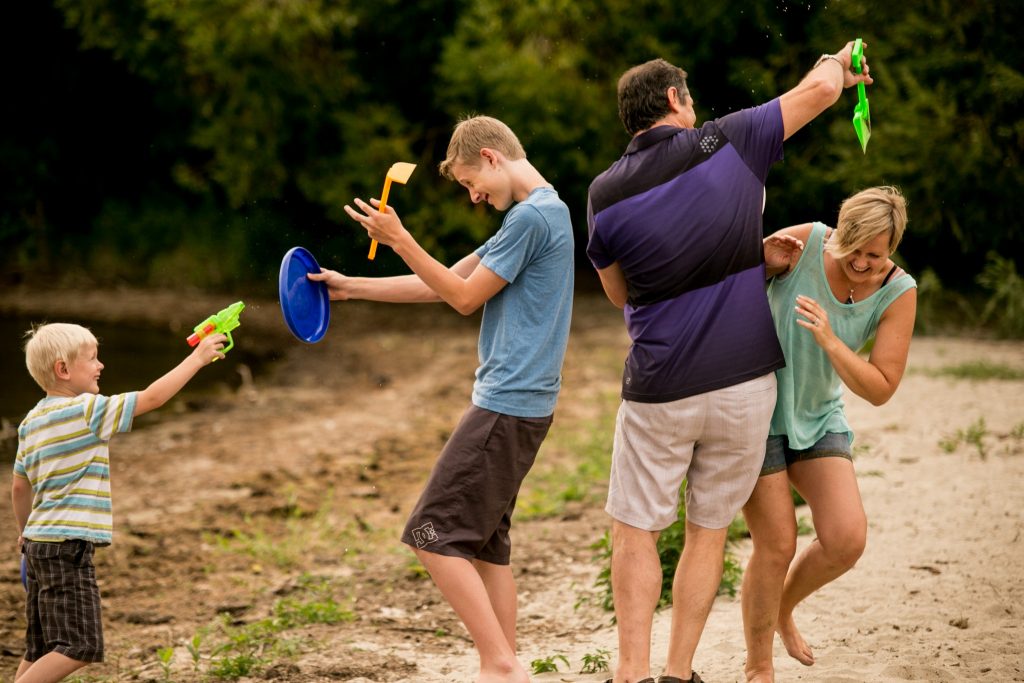 Victoria BC Family Photographer | family plays on the beach with water guns