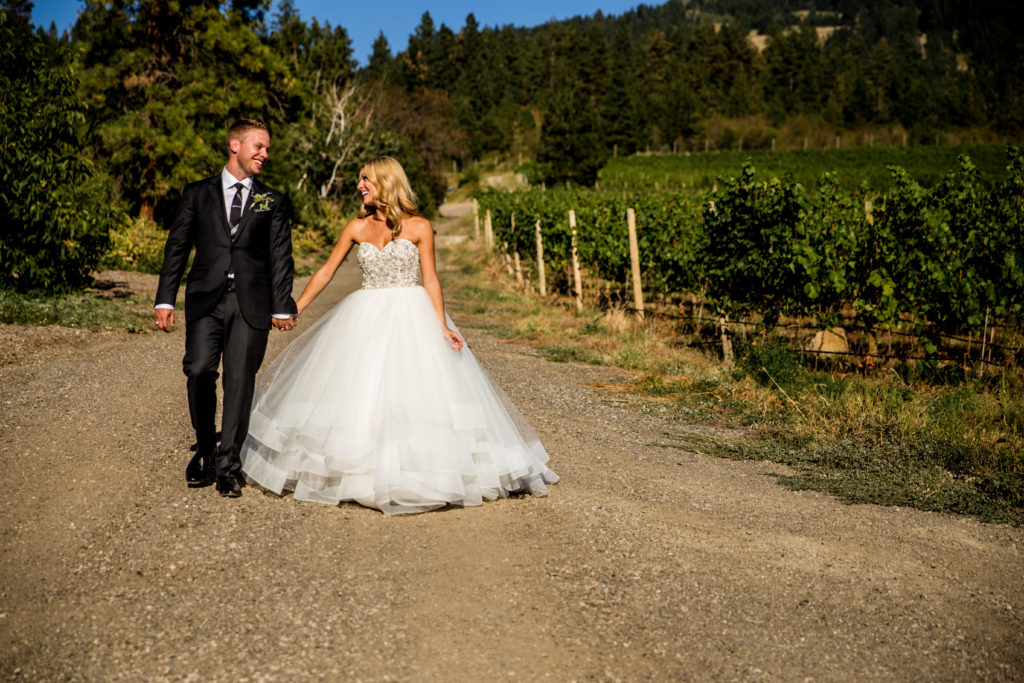 Stellavate Photography | Victoria BC wedding Photographer | bride and groom walking through vineyard at 50th parallel wines
